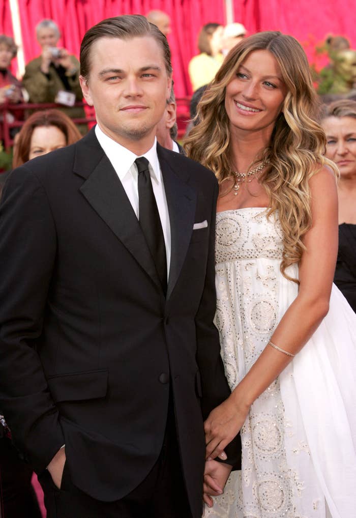 Leonardo DiCaprio in a tux and Gisele Bündchen in a strapless gown holding hands on the red carpet