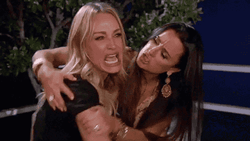 Kyle Richards holding back Taylor Armstrong