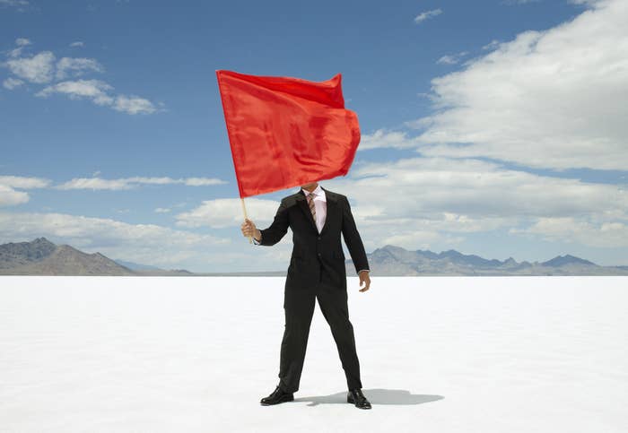 person with face covered with a large red flag