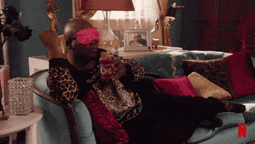 Titus Andromedon relaxing on the couch drinking a jar of pasta sauce in Unbreakable Kimmy Schmidt