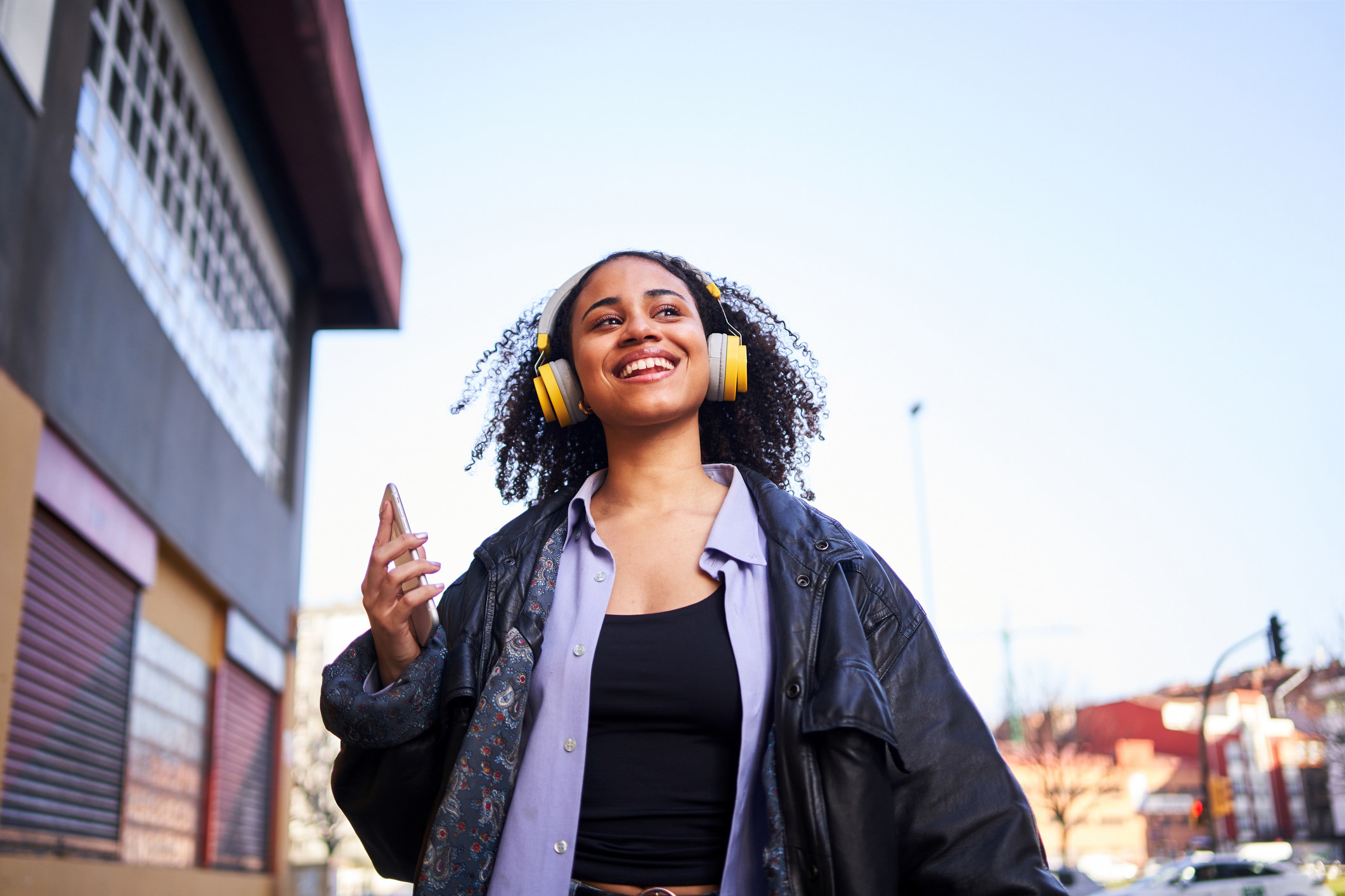 A woman listening to headphones while walking down the street