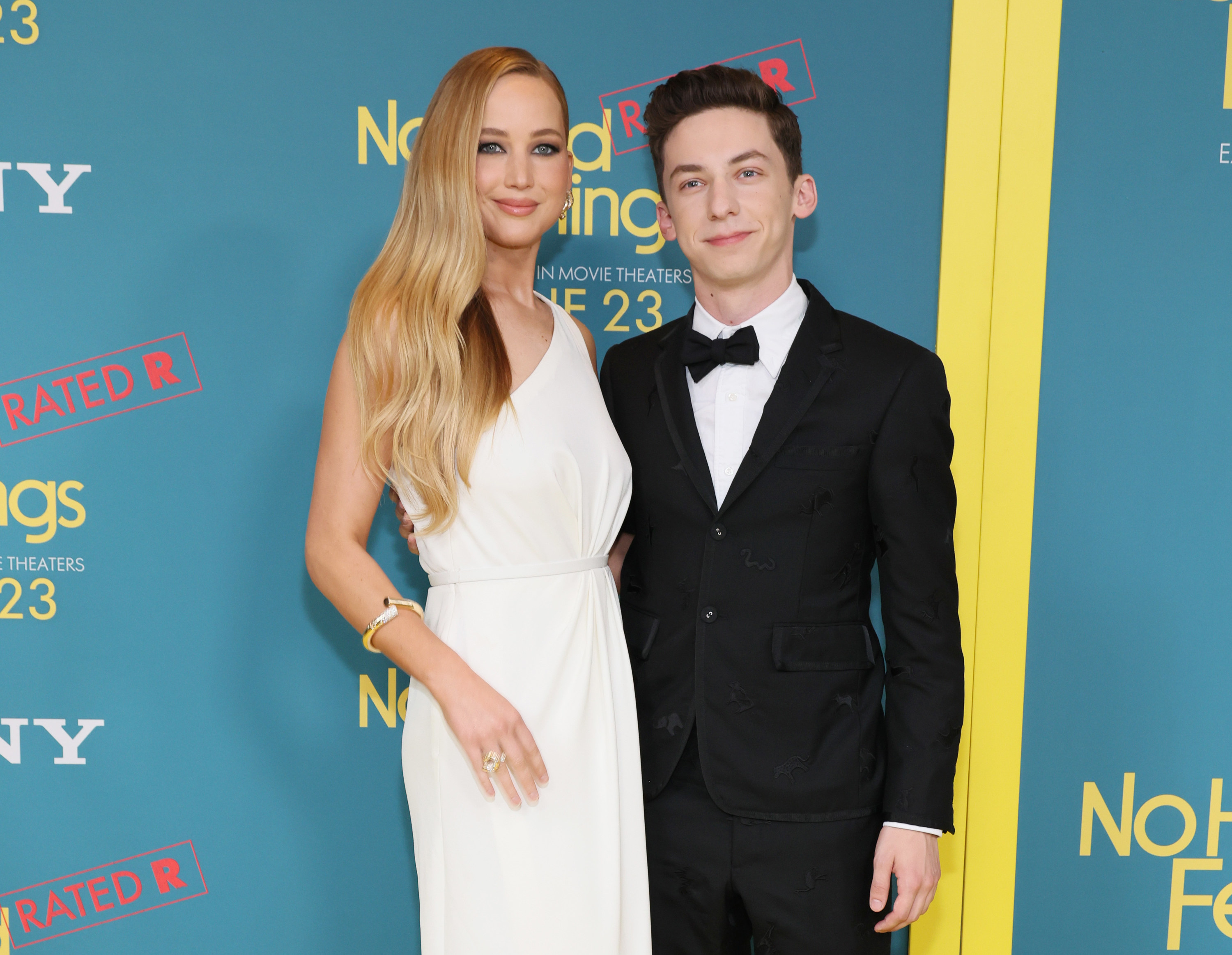 Close-up of Jennifer, in a sleeveless dress, and Andrew, in a suit and bow tie, at a media event
