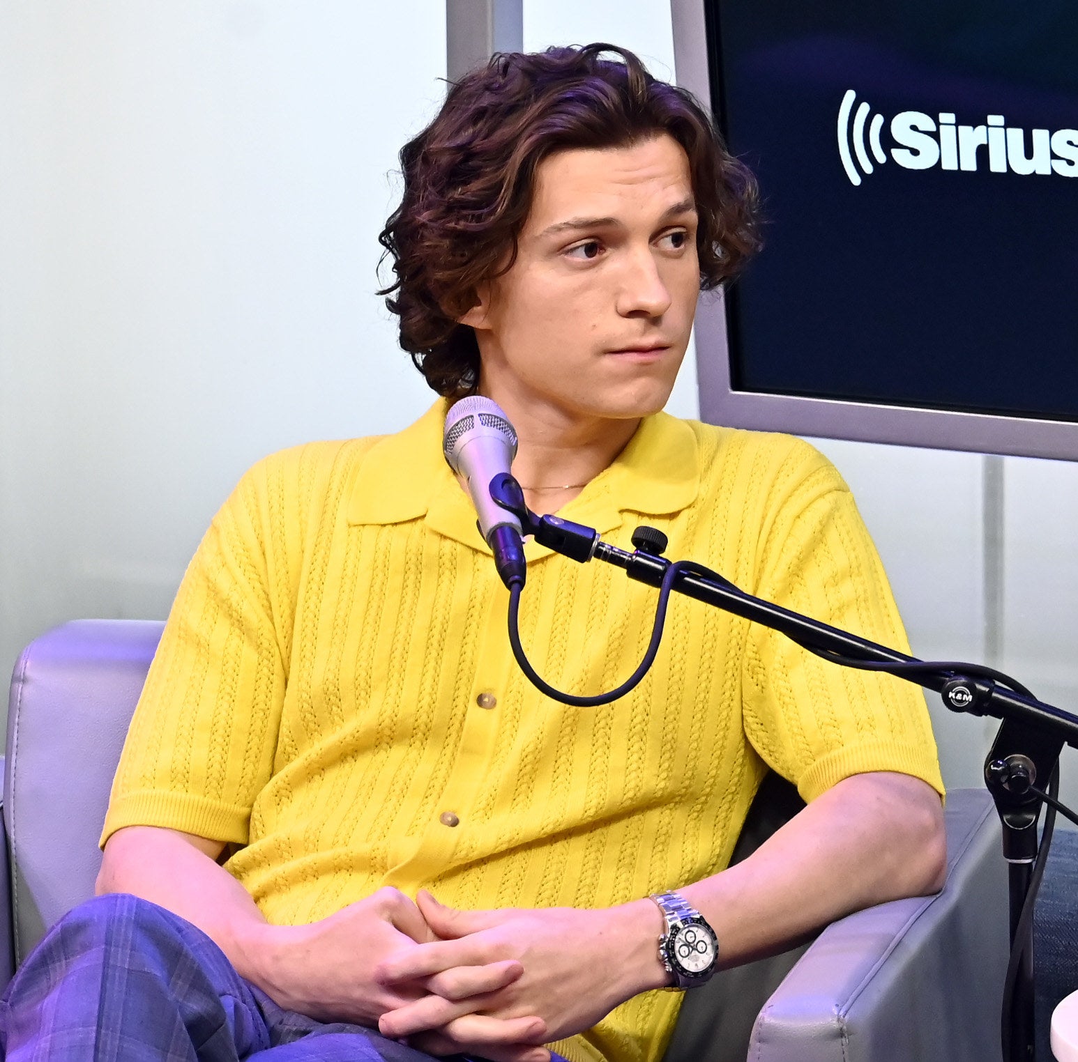 Close-up of Tom sitting with a microphone in front of him