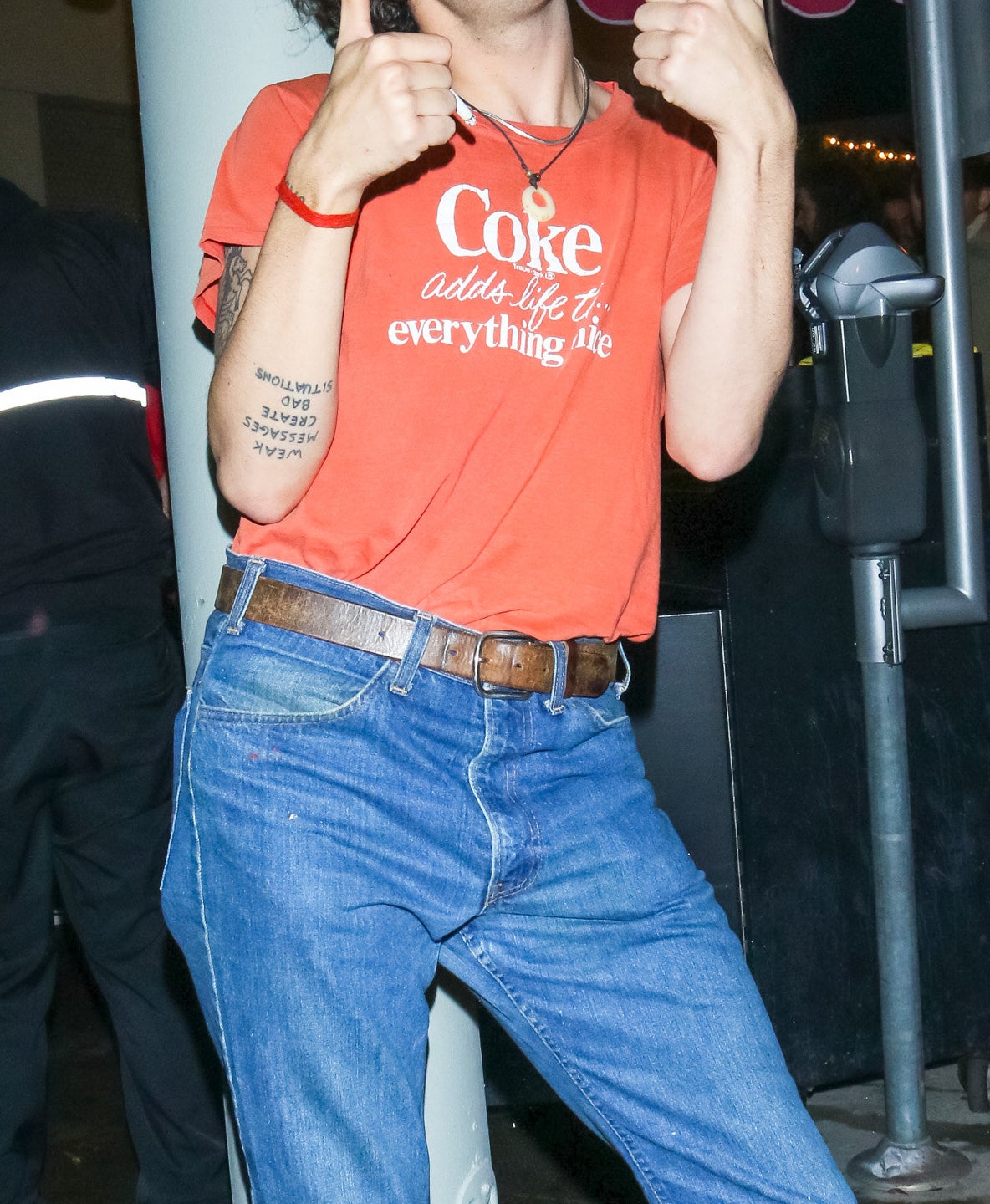 Close-up of Matty smiling, wearing a &quot;Coke adds life to everything nice&quot; T-shirt, and giving two thumbs-up