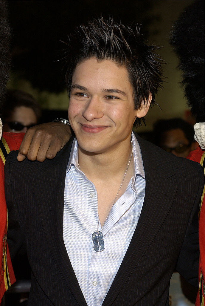 closeup of him with tall spiky hair and a blazer