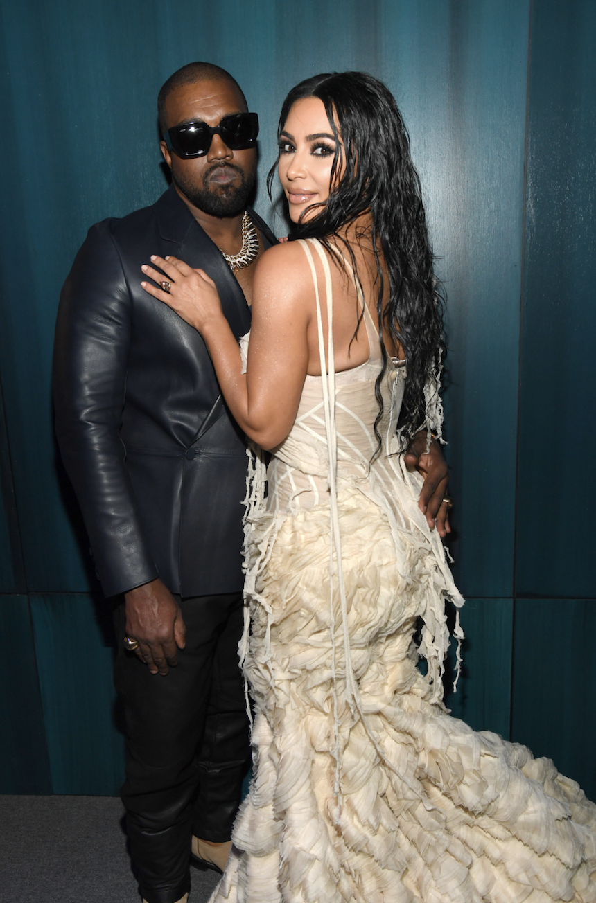 Ye and Kim facing each other and touching each other at a media event