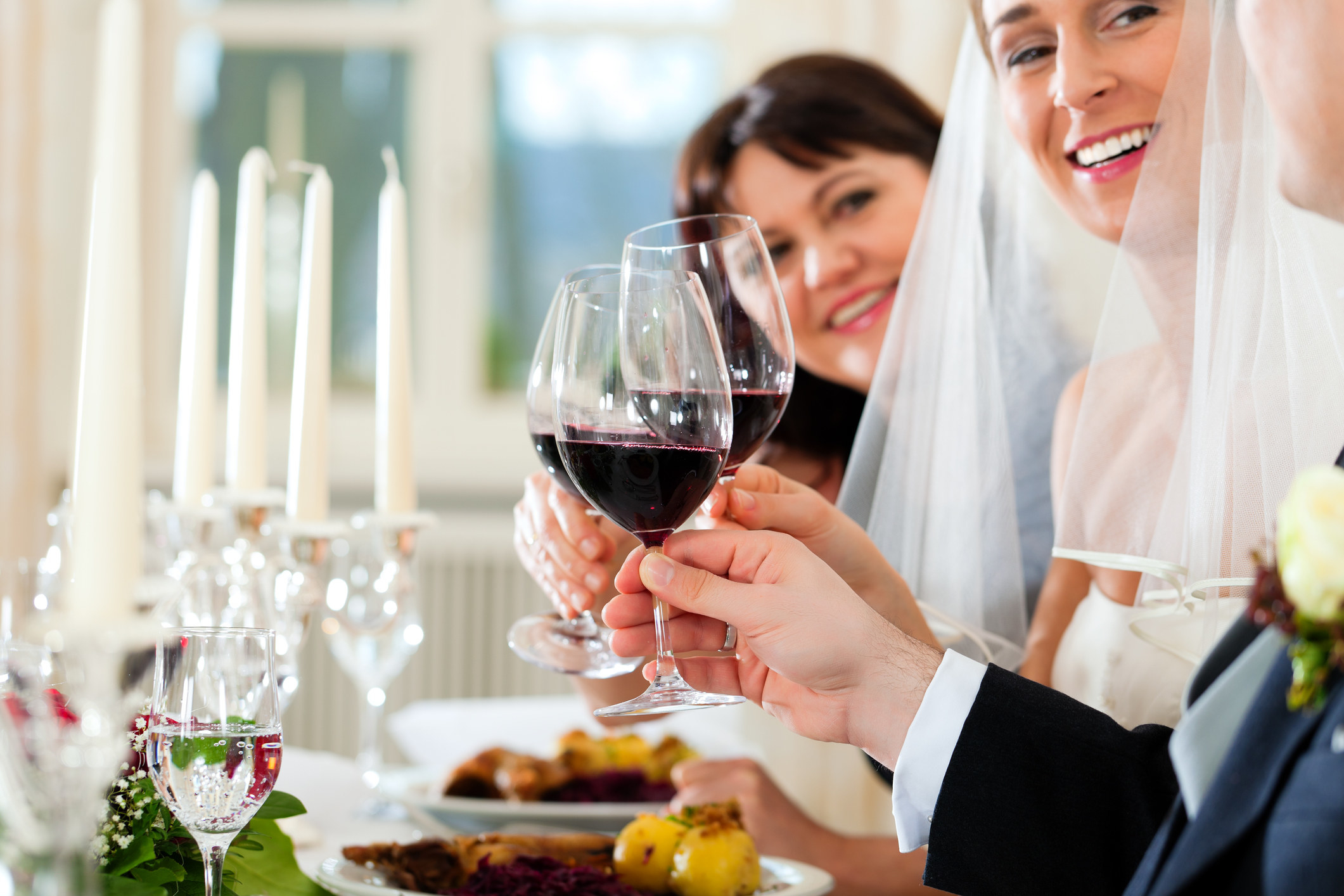 A bride and groom clinking wine glasses