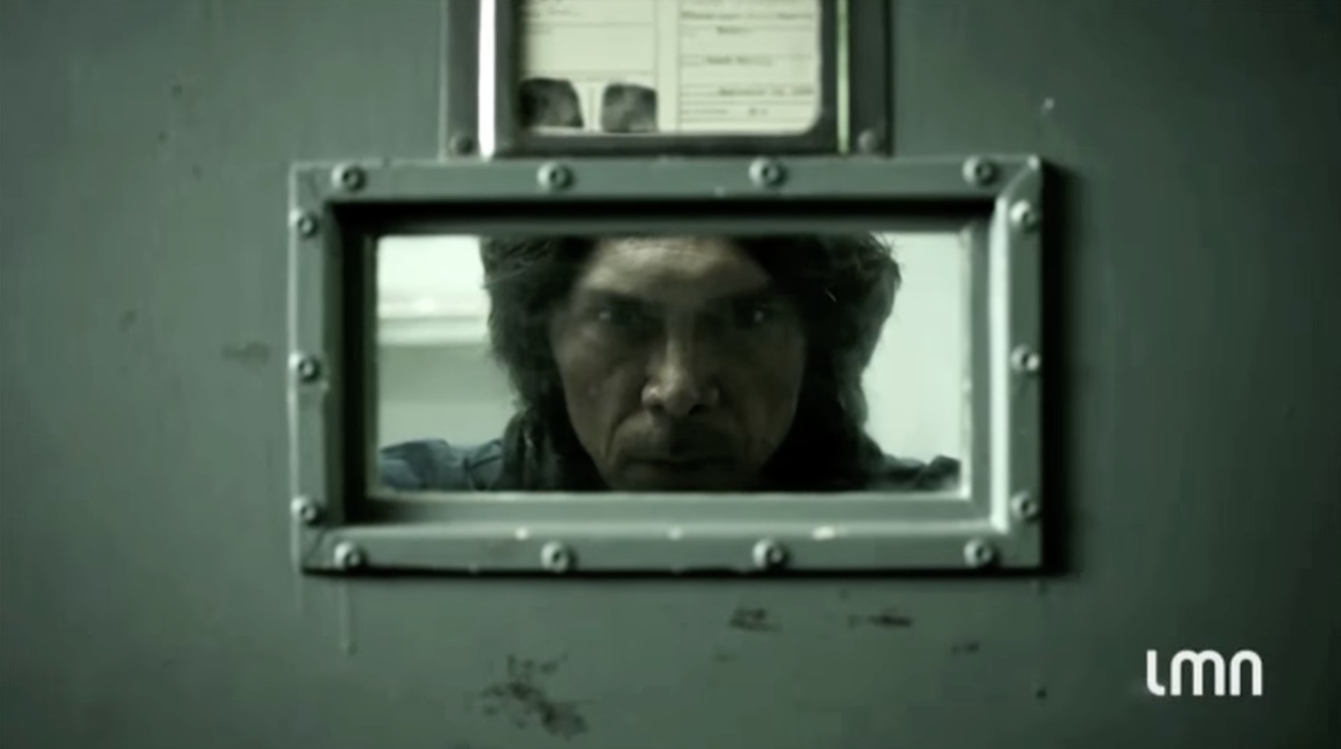 Movie still for the film &quot;The Night Stalker&quot; featuring Lou Diamond Phillips with a menacing face; he&#x27;s looking through a small prison window