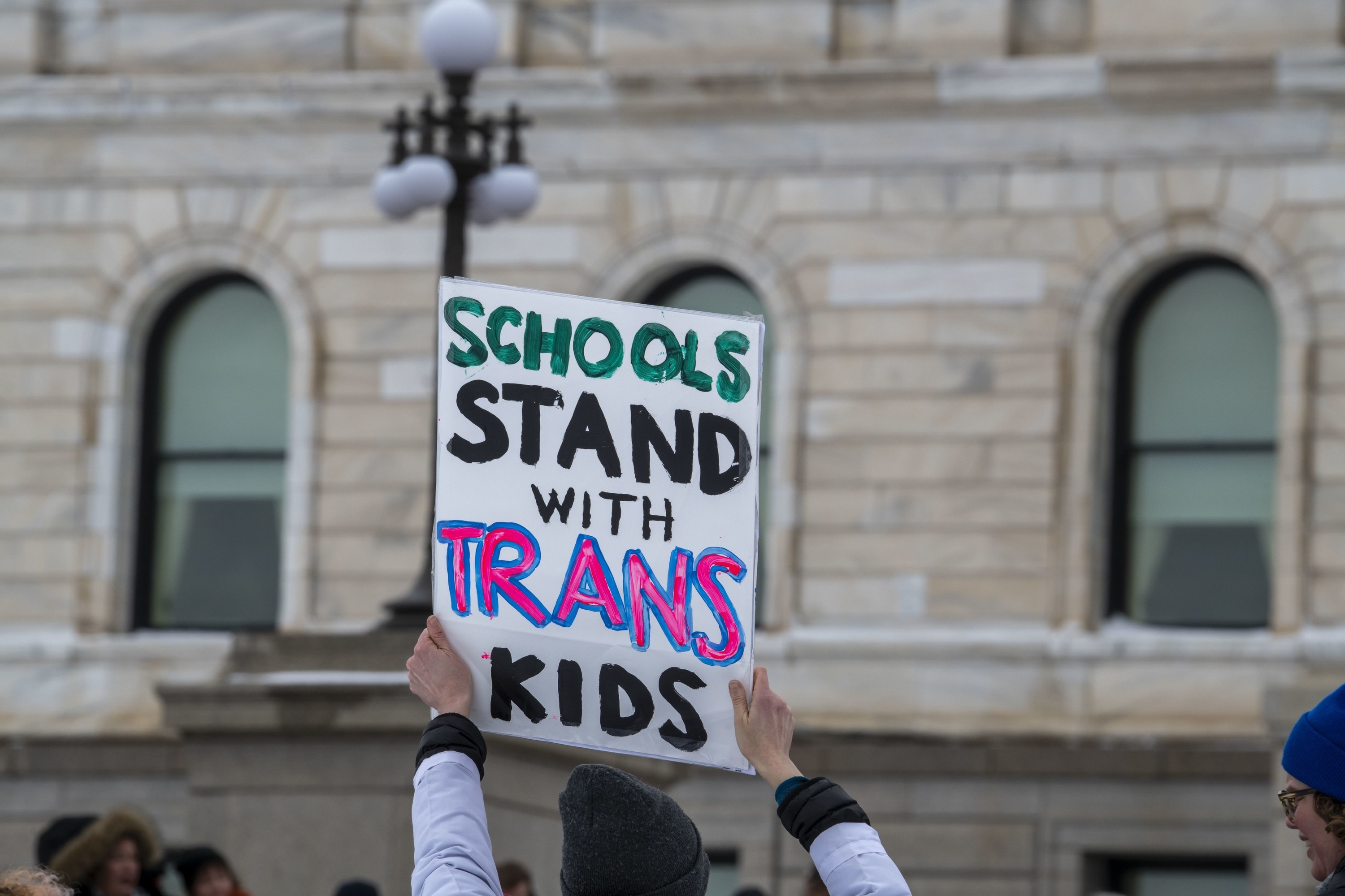 A sign saying, &quot;Schools Stand with Trans Kids&quot;
