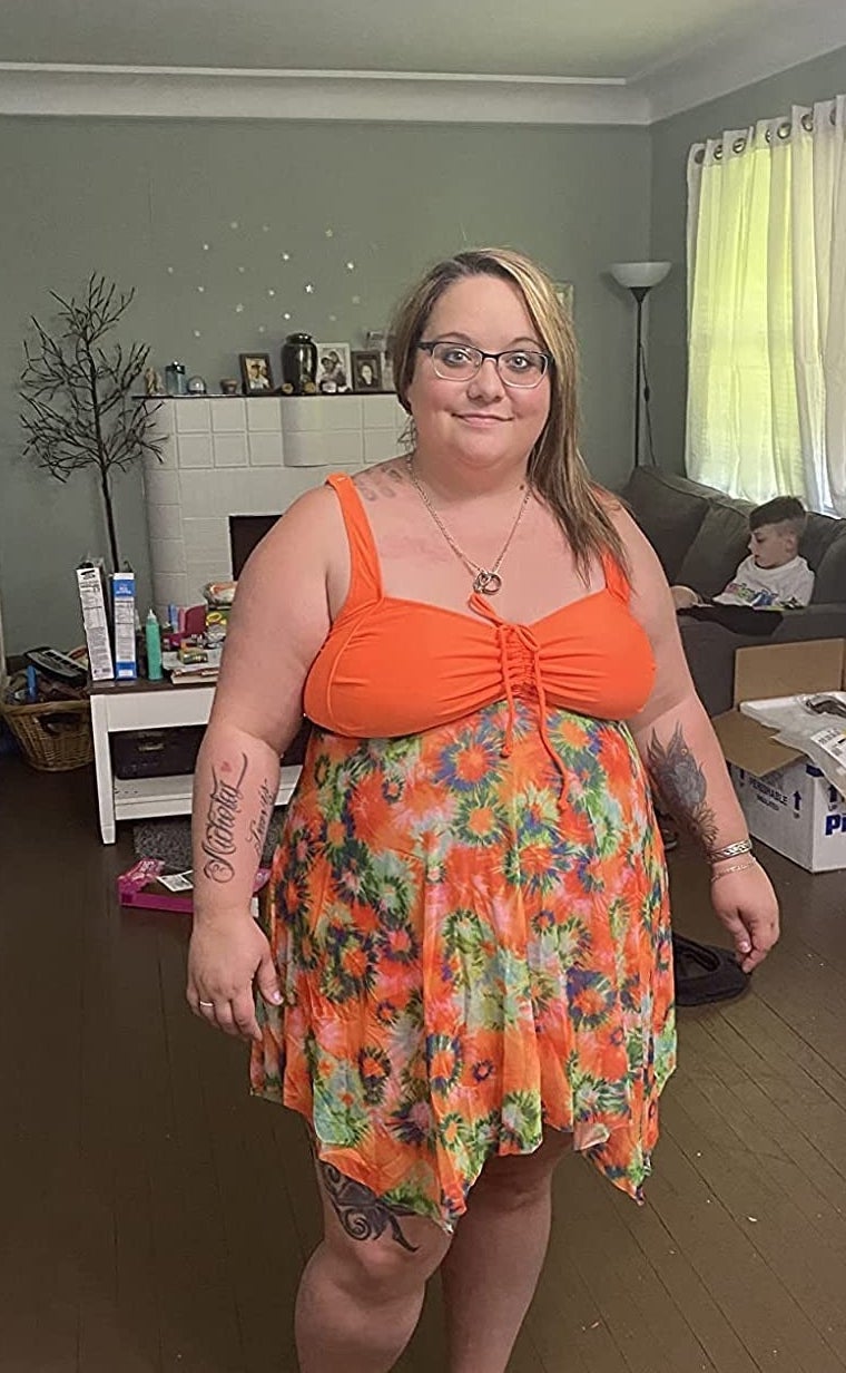 Reviewer wearing the swimsuit in the orange flower print