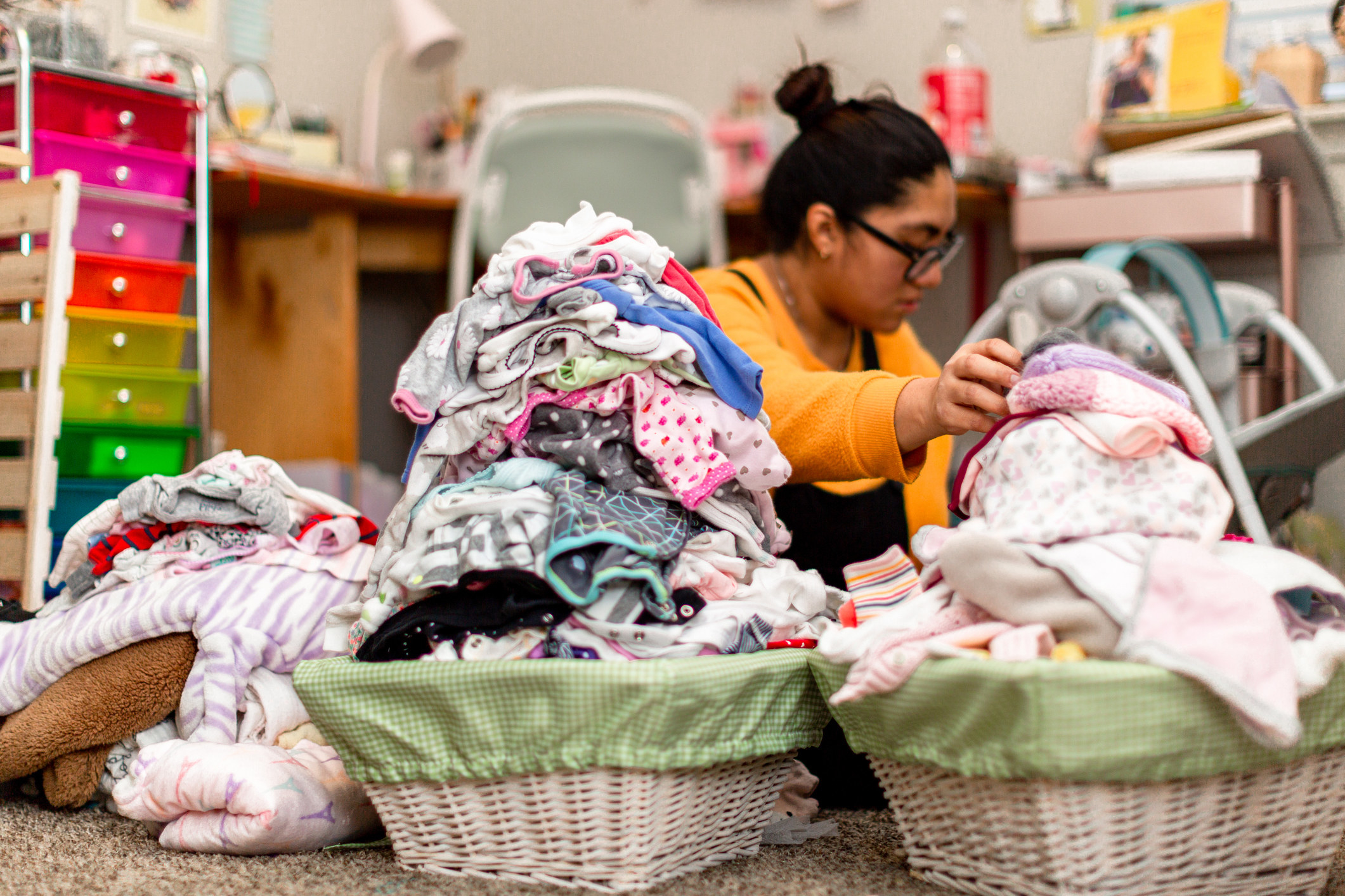 A woman folding baby clothes