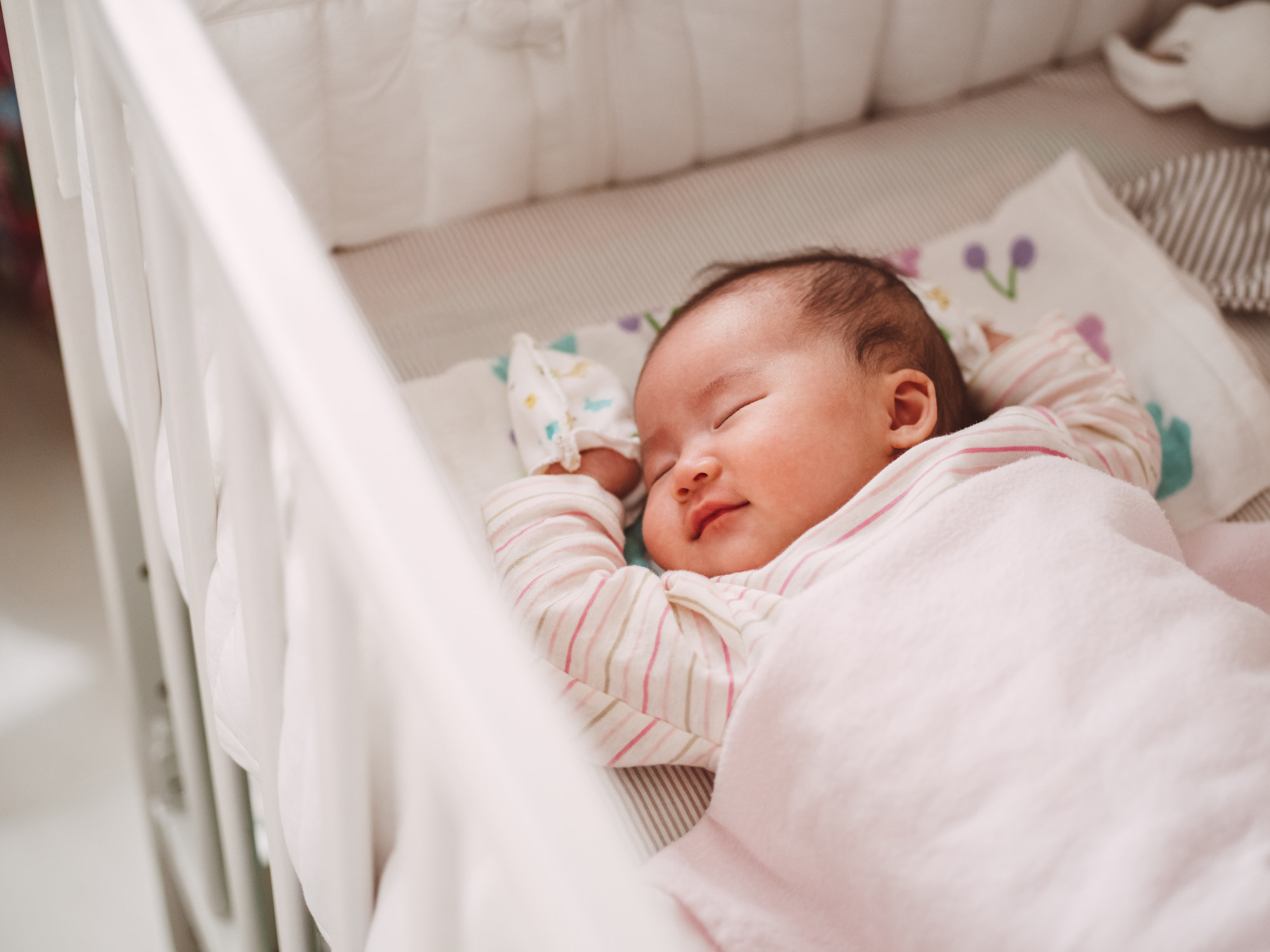 A baby sleeping in its crib