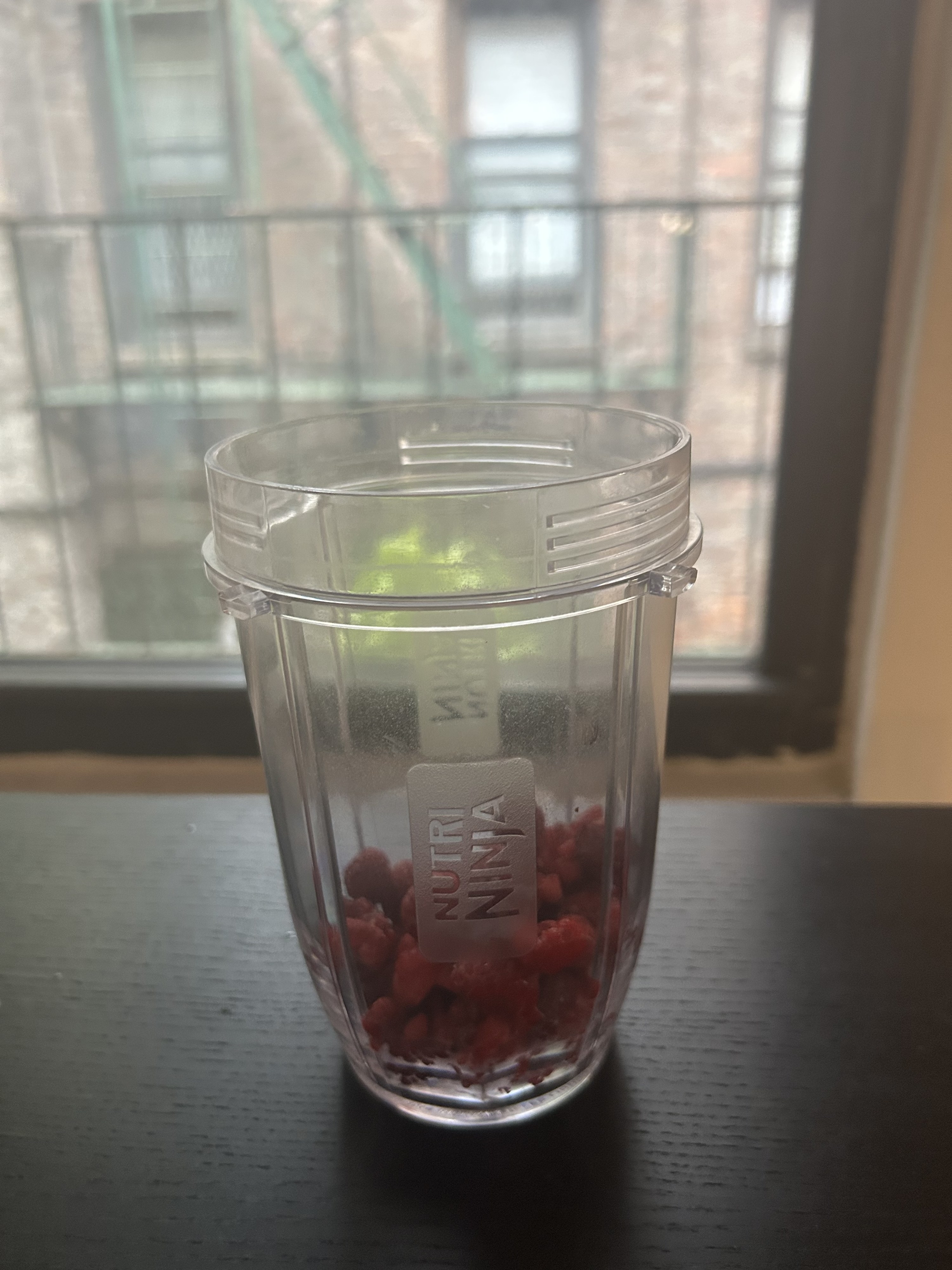 Raspberries sit in a blender