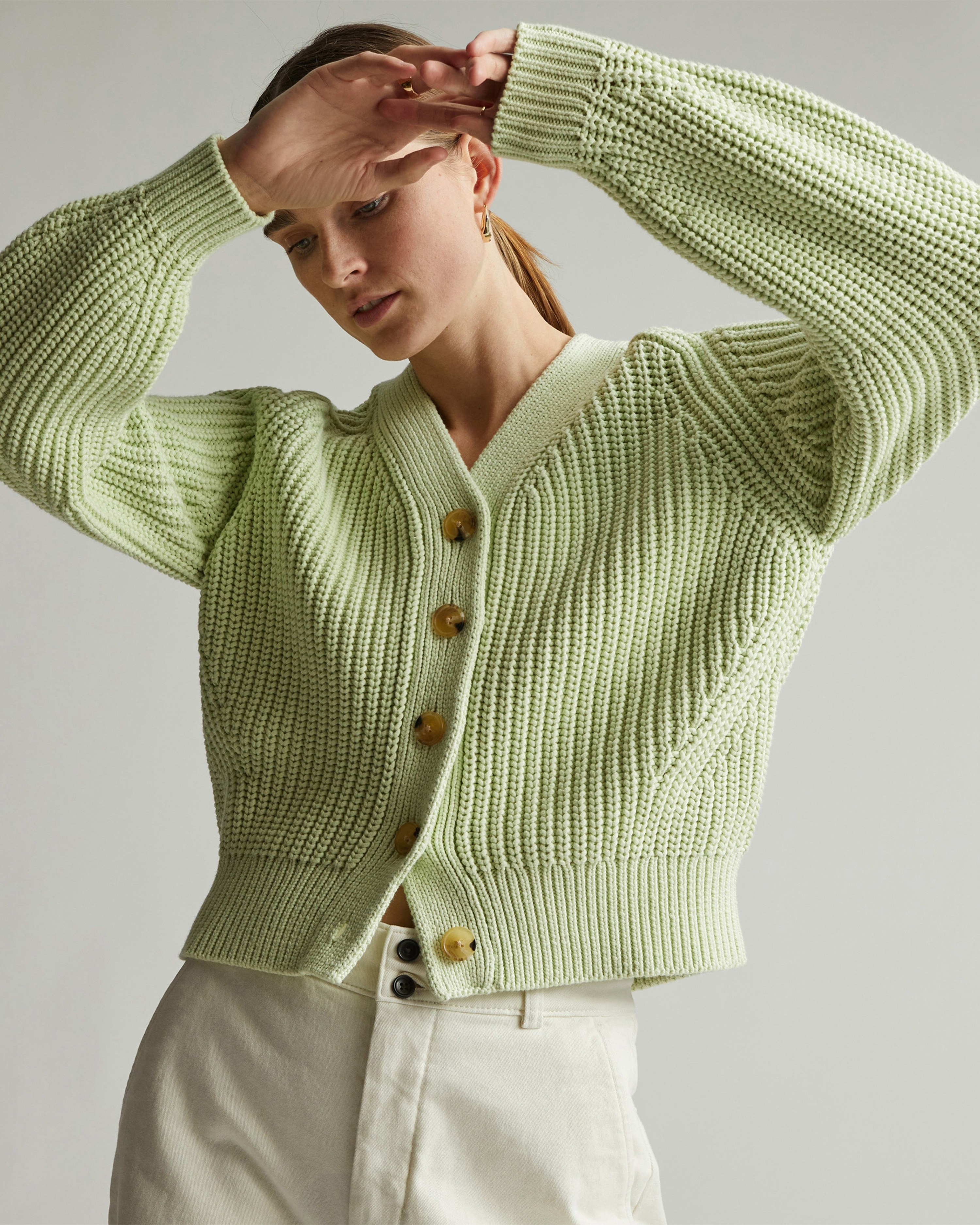 model in a green cotton cardigan