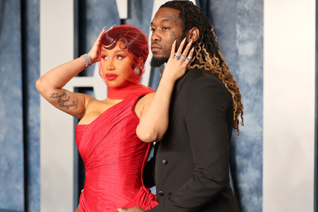 Cardi posing with Offset, who has his arms around her, on the red carpet