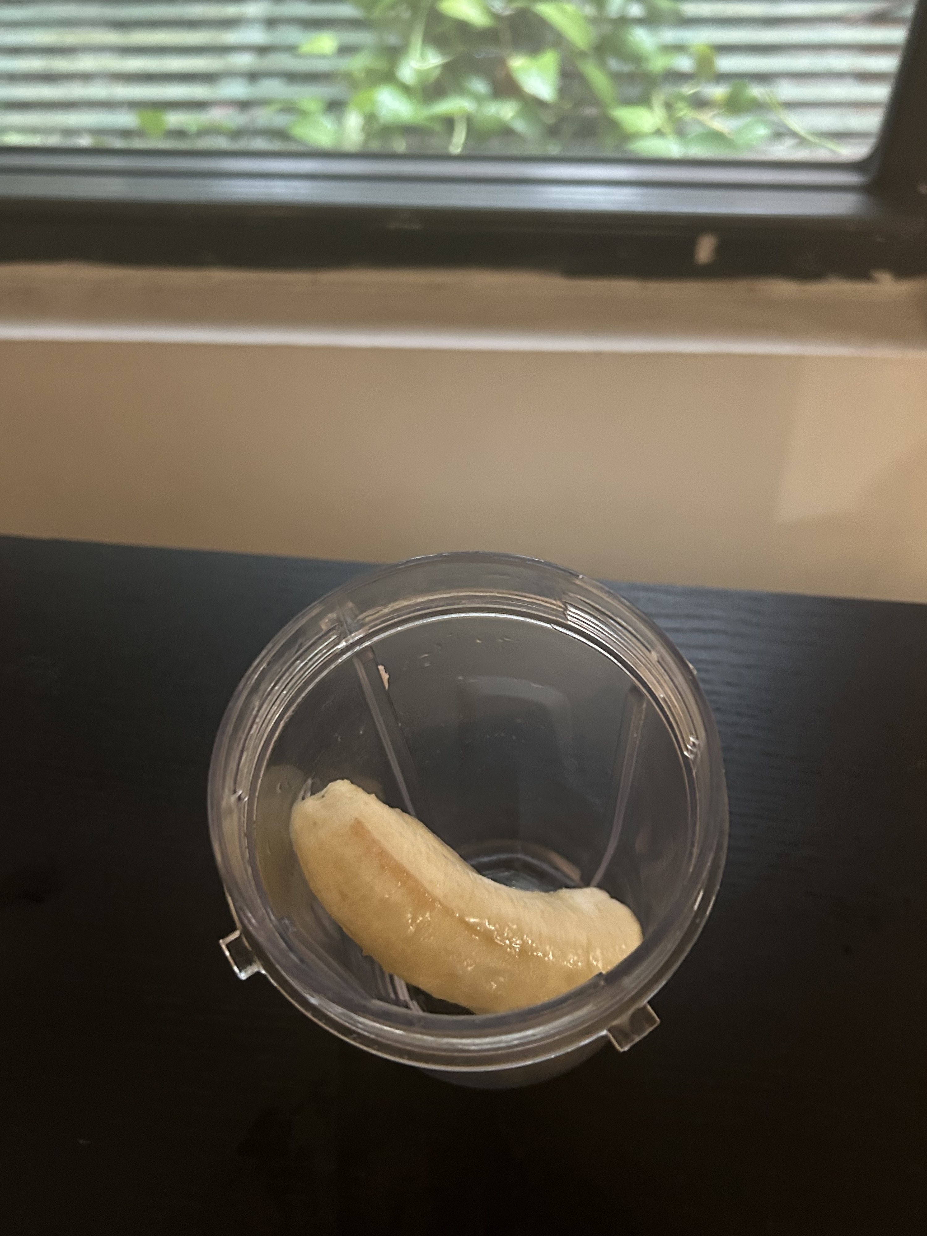 A frozen banana sits in a blender