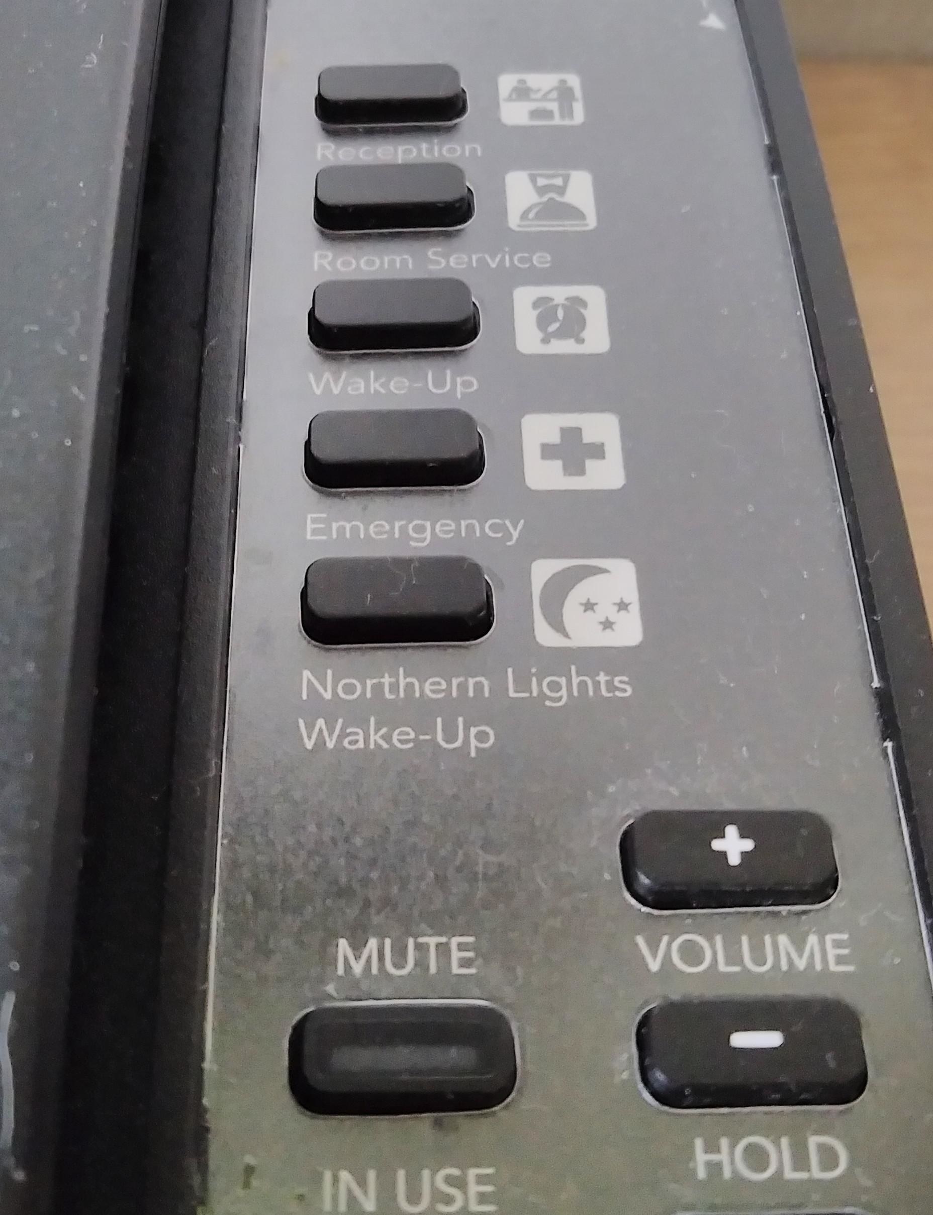 a regular hotel phone with a button that says norther lights wake up