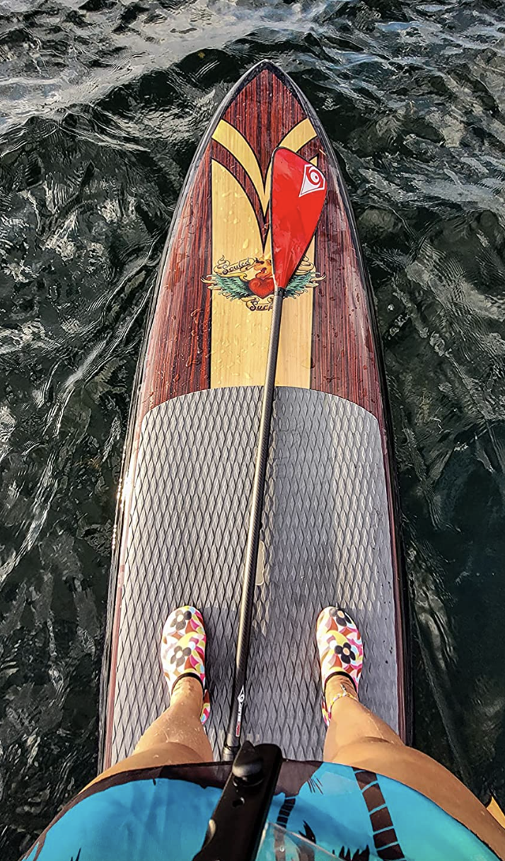 reviewer standing on paddleboard wearing floral-print water shoes