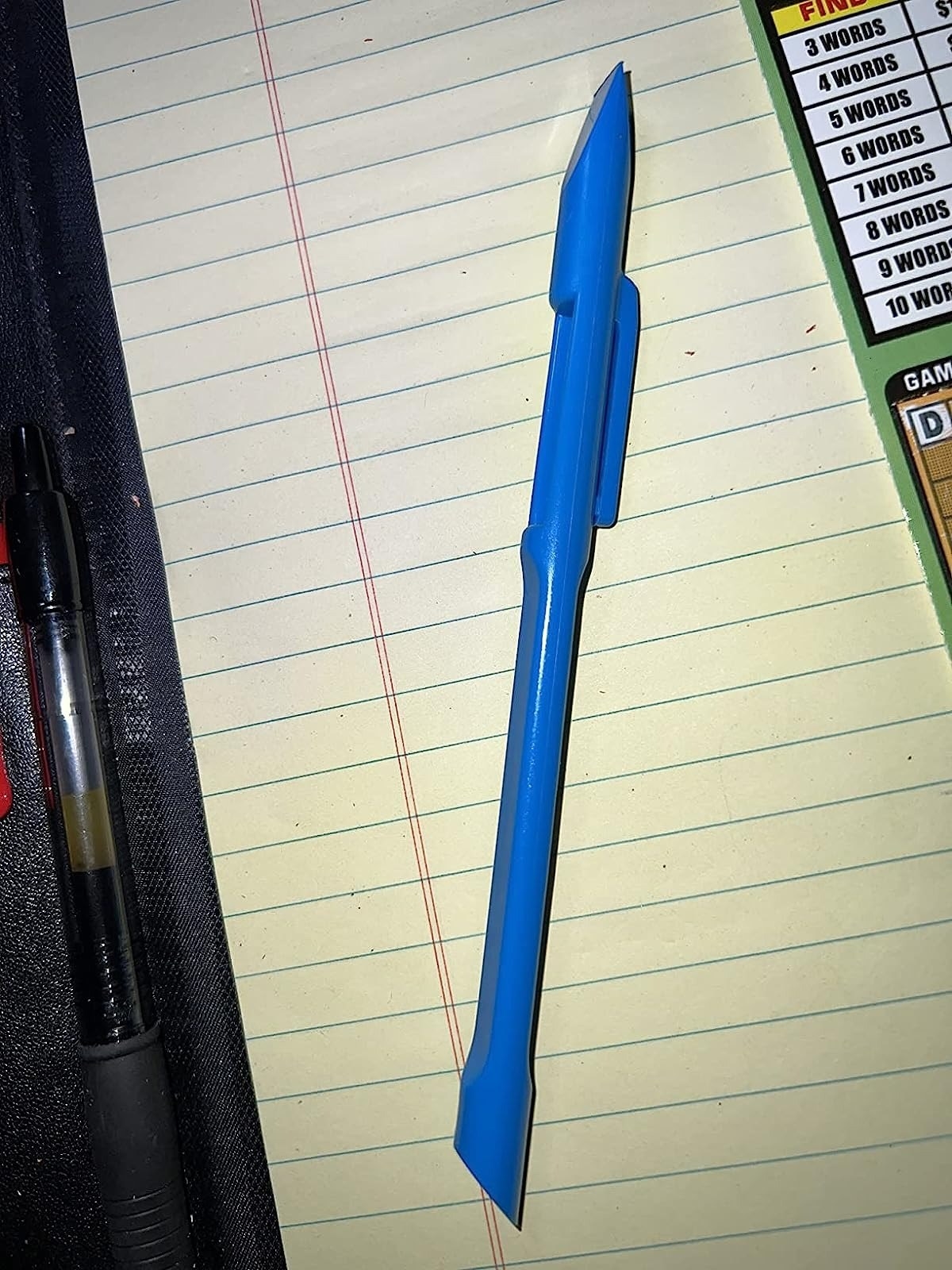 the blue scraper tool on lined notepad