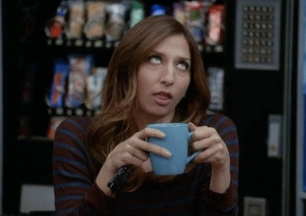A woman holding a coffee mug and rolling her eyes