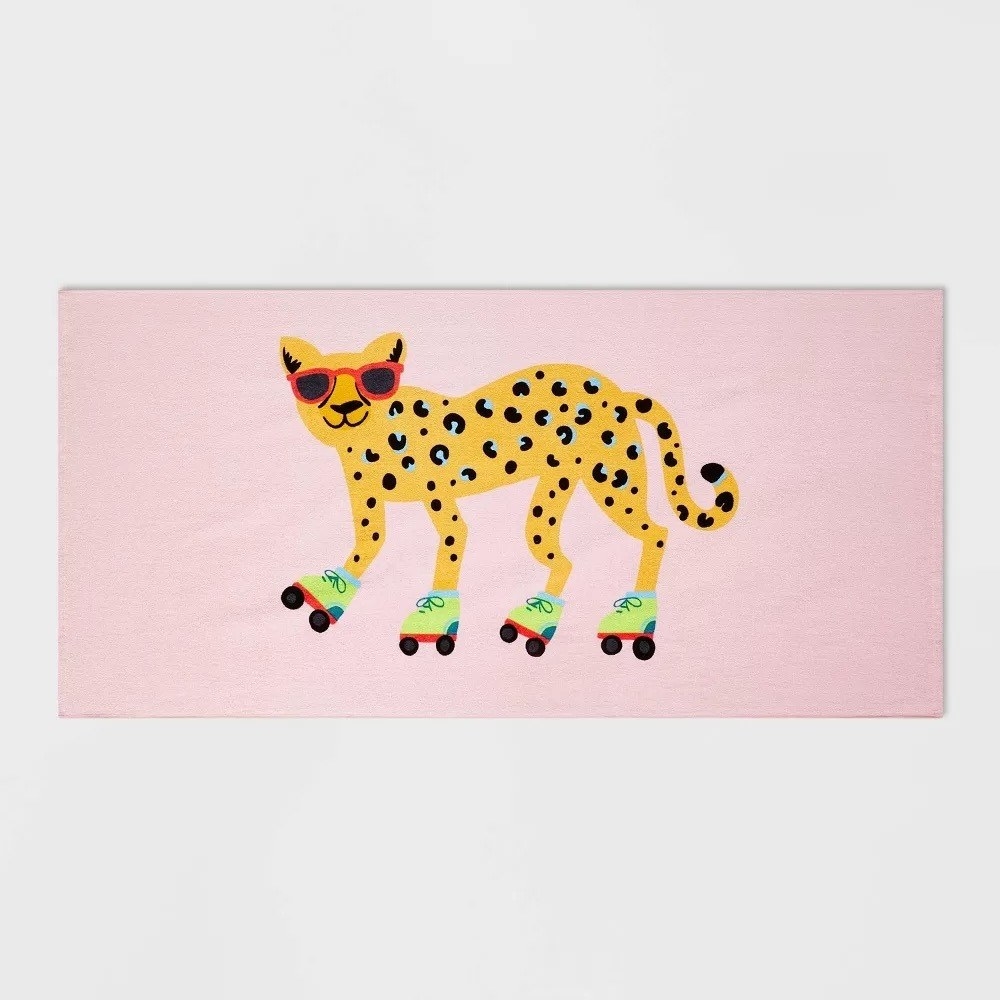 The towel with a pink background and a cheetah wearing sunglasses and rollerblades