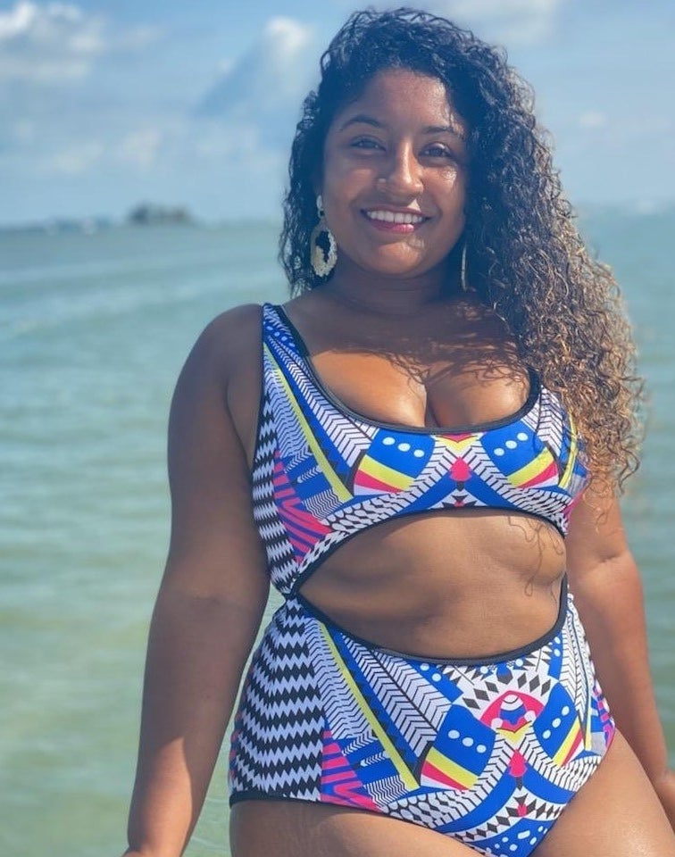 reviewer wearing black, pink, yellow, white, and blue-printed monokini