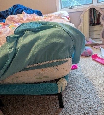 a child&#x27;s bed with pool noodles around the sharp frame edges