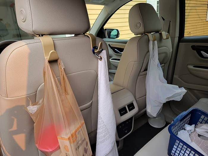 Reviewer&#x27;s photo of the backseat of a car with groceries hanging off hooks.