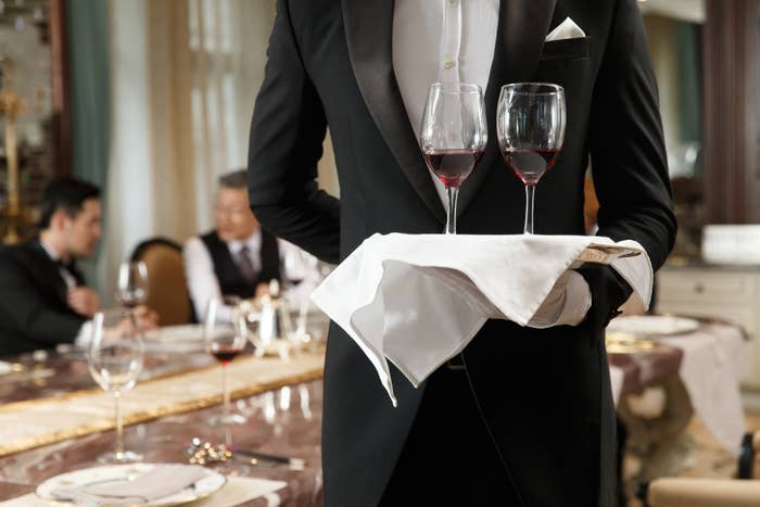 server holding a tray of wine glasses