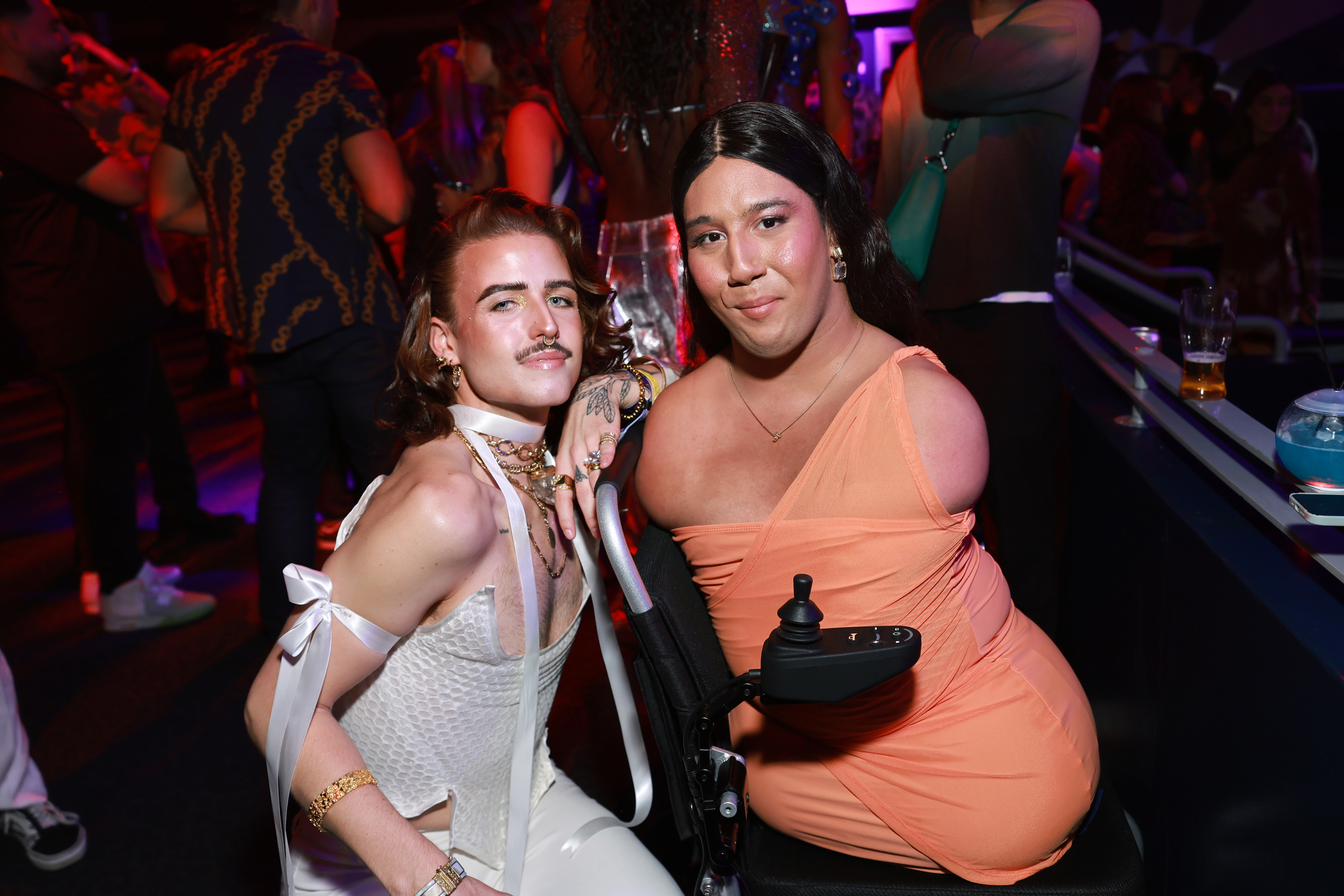 RJ Chumbley and Gabe Adams attend Instagram Night Out at VidCon 2023, photographed together on the dance floor in a silver and peach outfit respectively.