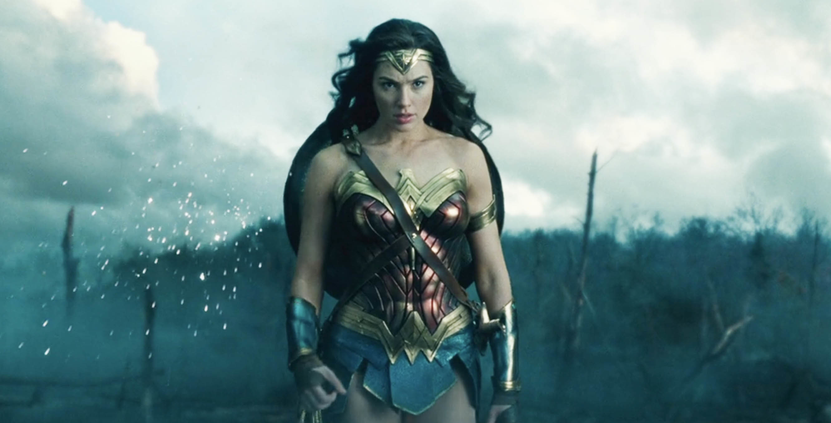 Gal Gadot as Wonder Woman walking through a battlefield