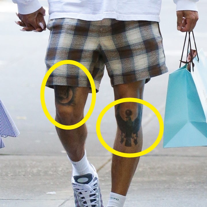 Jesse Williams and his partner walking down the street with circles over his tattoos