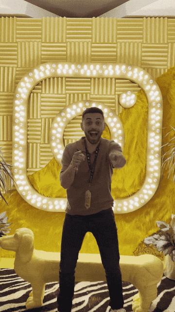 Josh Rincon in the Meta Creator Lounge at VidCon, making finger guns in front a yellow wall with the Instagram logo in lights.