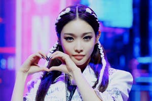 K-pop singer with hands in heart shape.