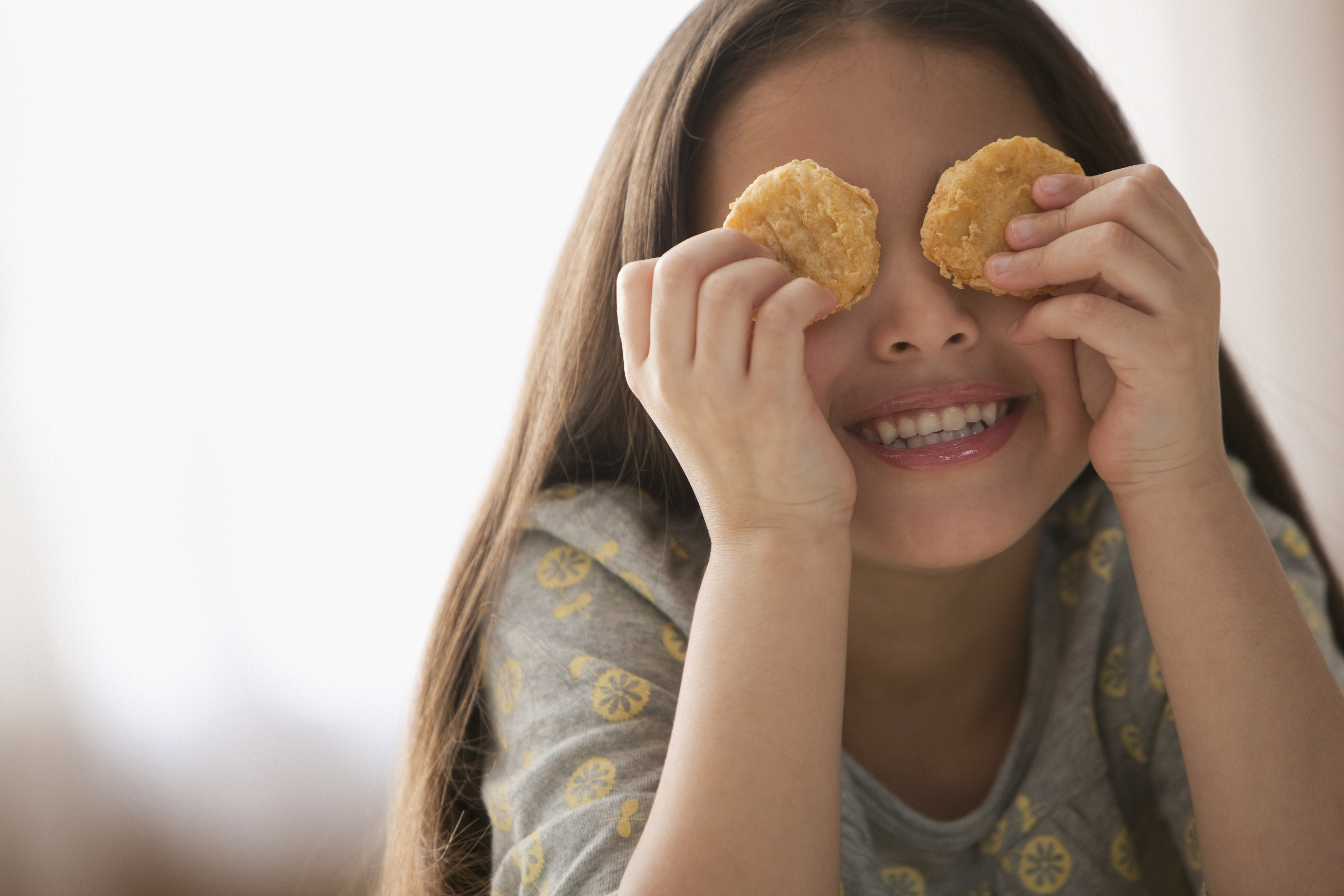little girl playing with chicken nuggets