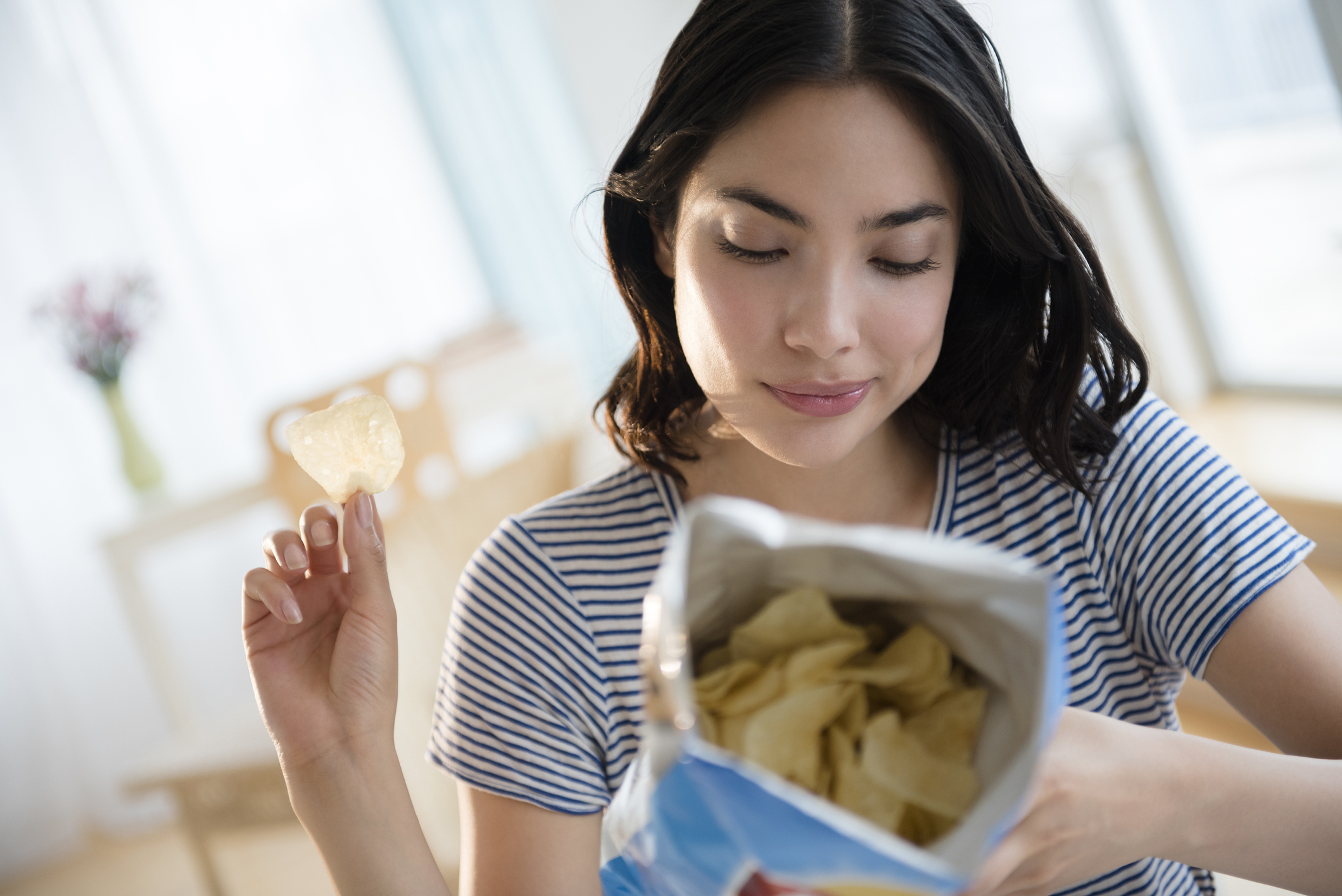 A woman eating potato chips