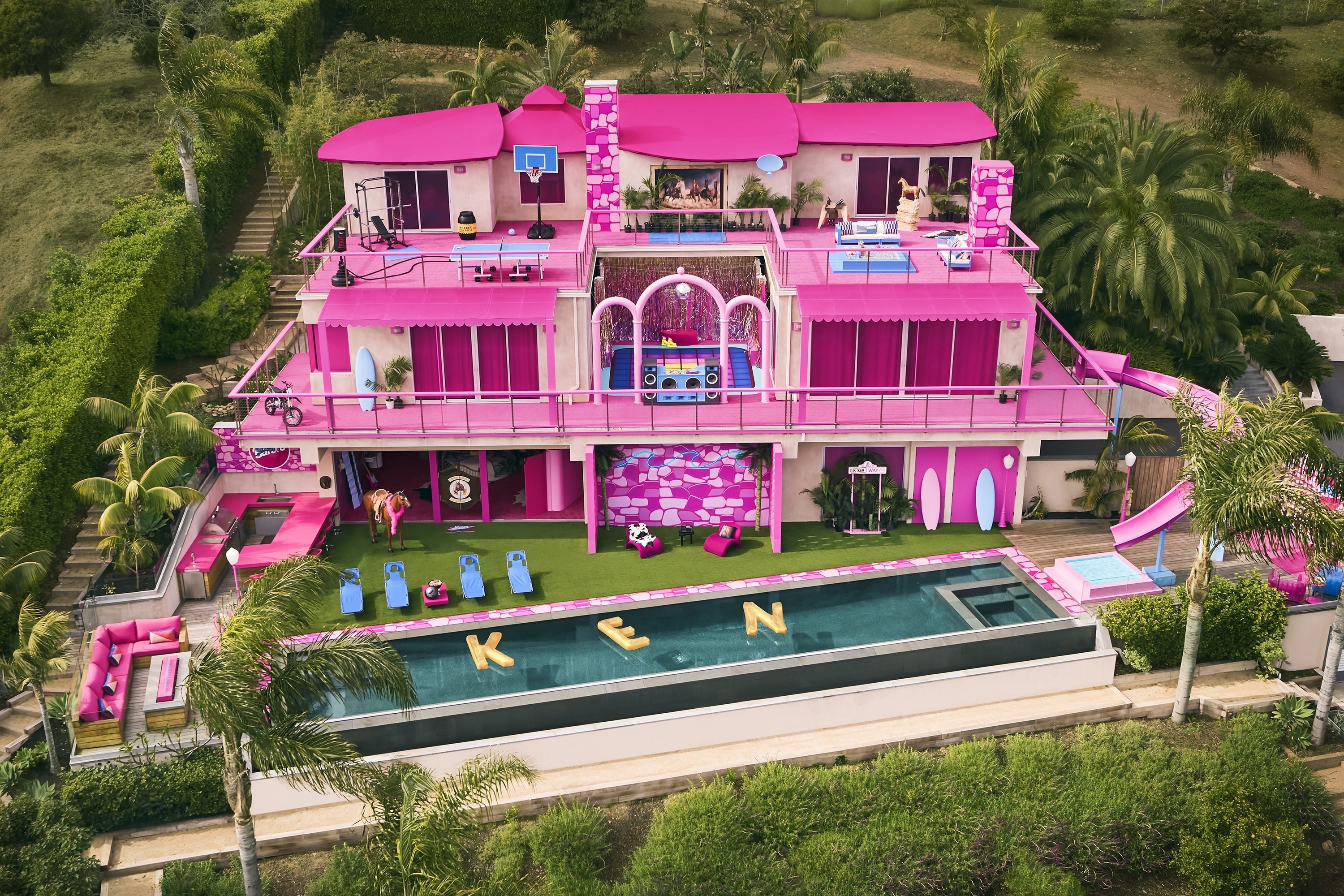 An aerial shot of the home, which features a long pool with floaties that spell out Ken