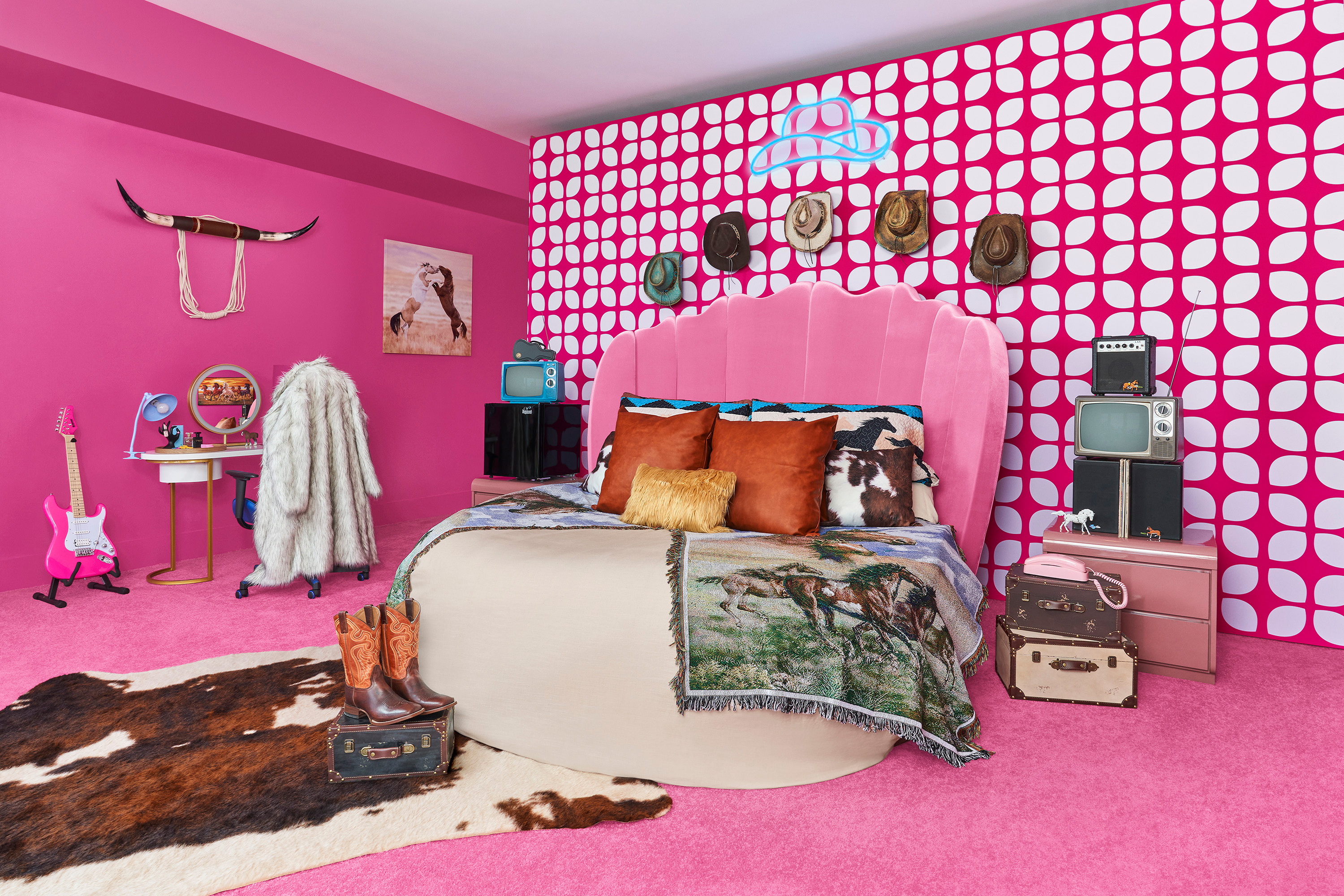 A cowboy-themed bedroom that has a circular bed with cowboy hats on the wall