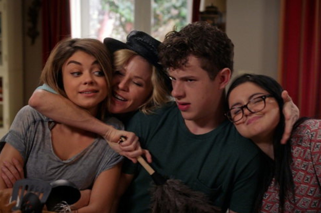 the dunphy children and claire from modern family in a group hug