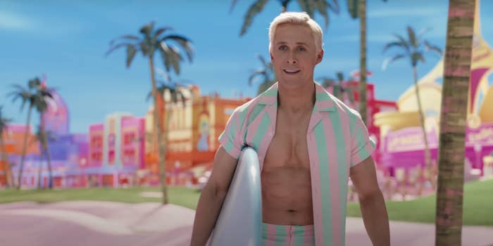 A close-up of Ryan Gosling as Ken with his shirt open and holding a surfboard
