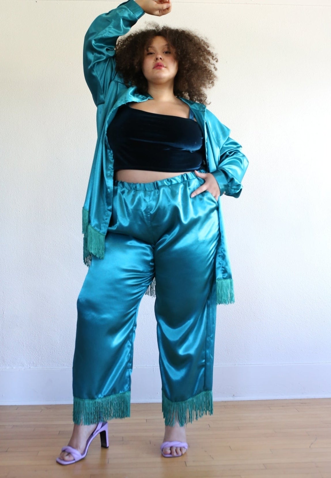 A model posing in teal pants with fringe