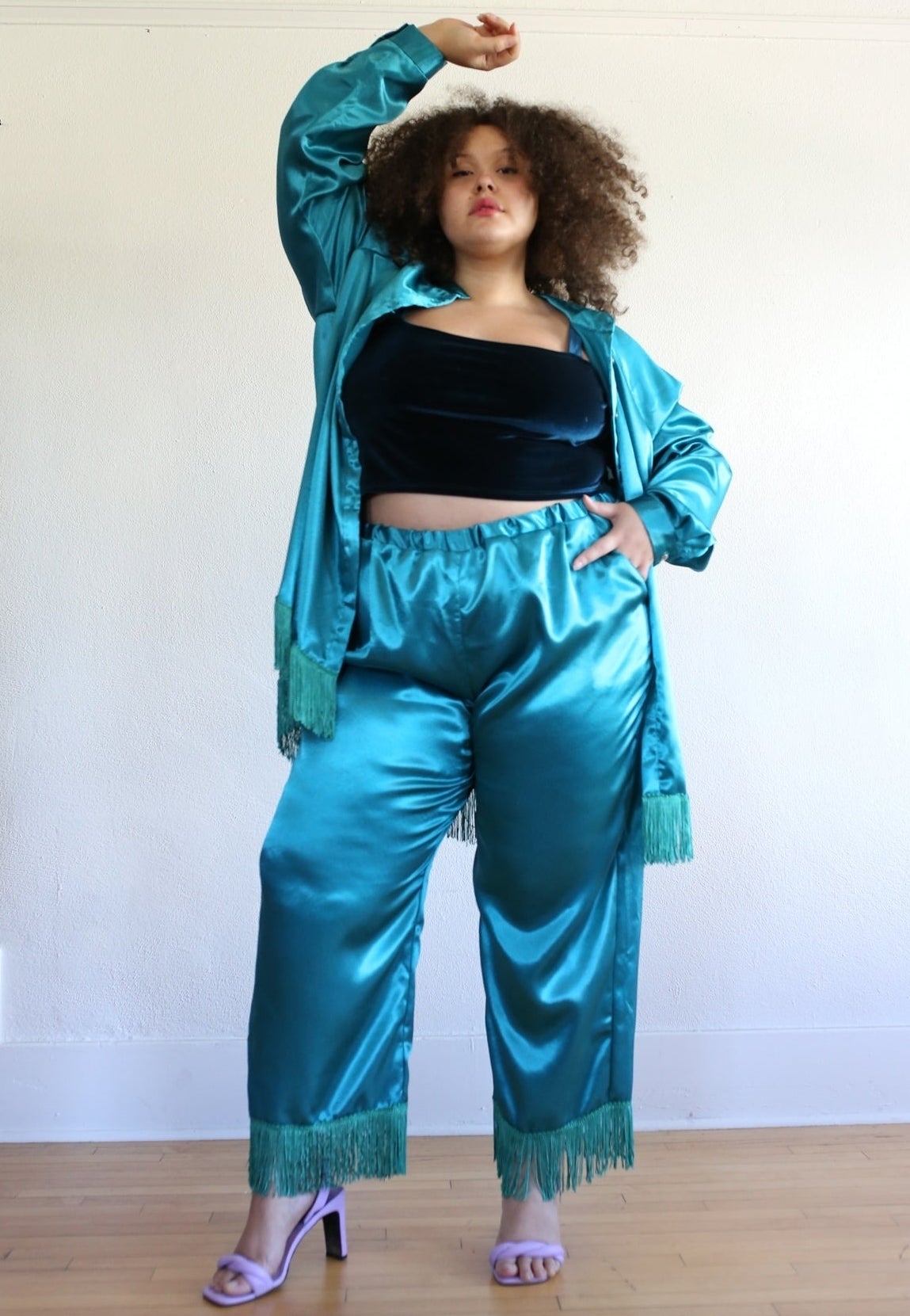A model posing in teal pants with fringe