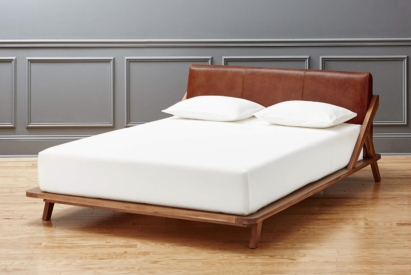 A wood and leather bed is shown