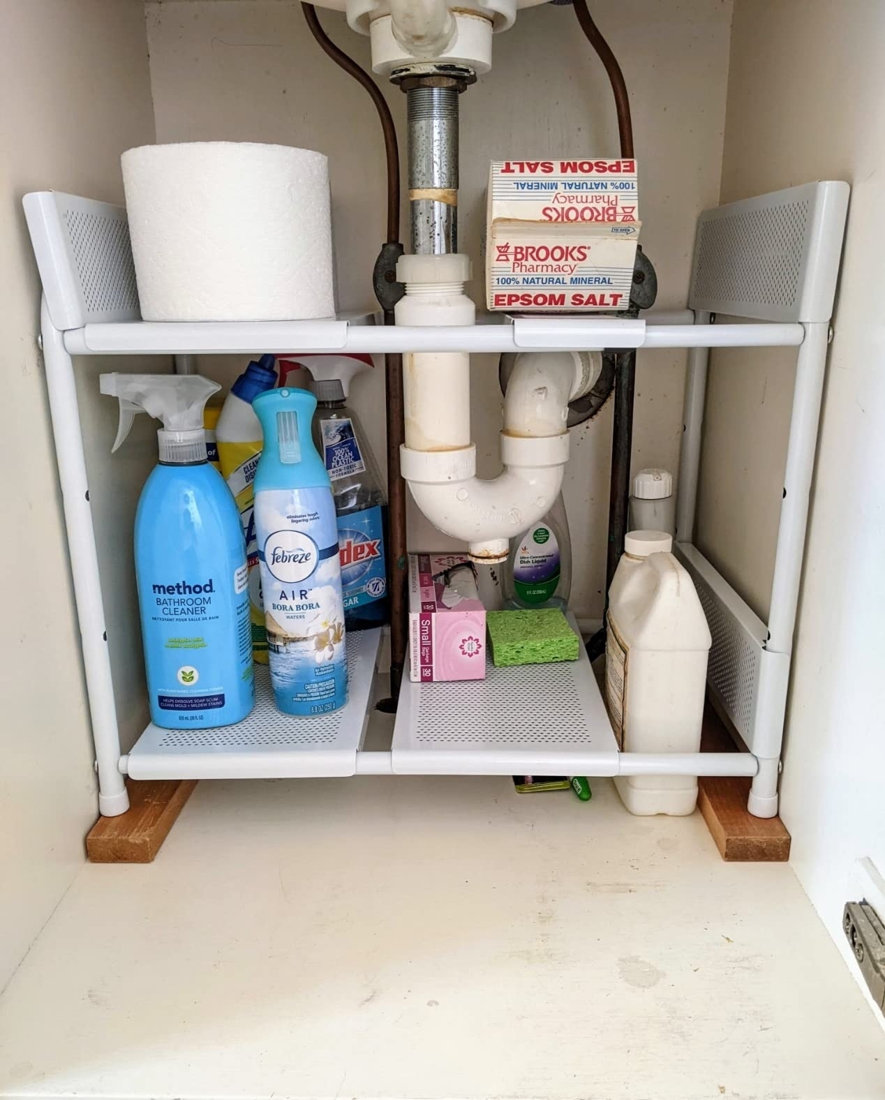 Reviewer&#x27;s photo of an under sink storage rack with cleaning supplies.