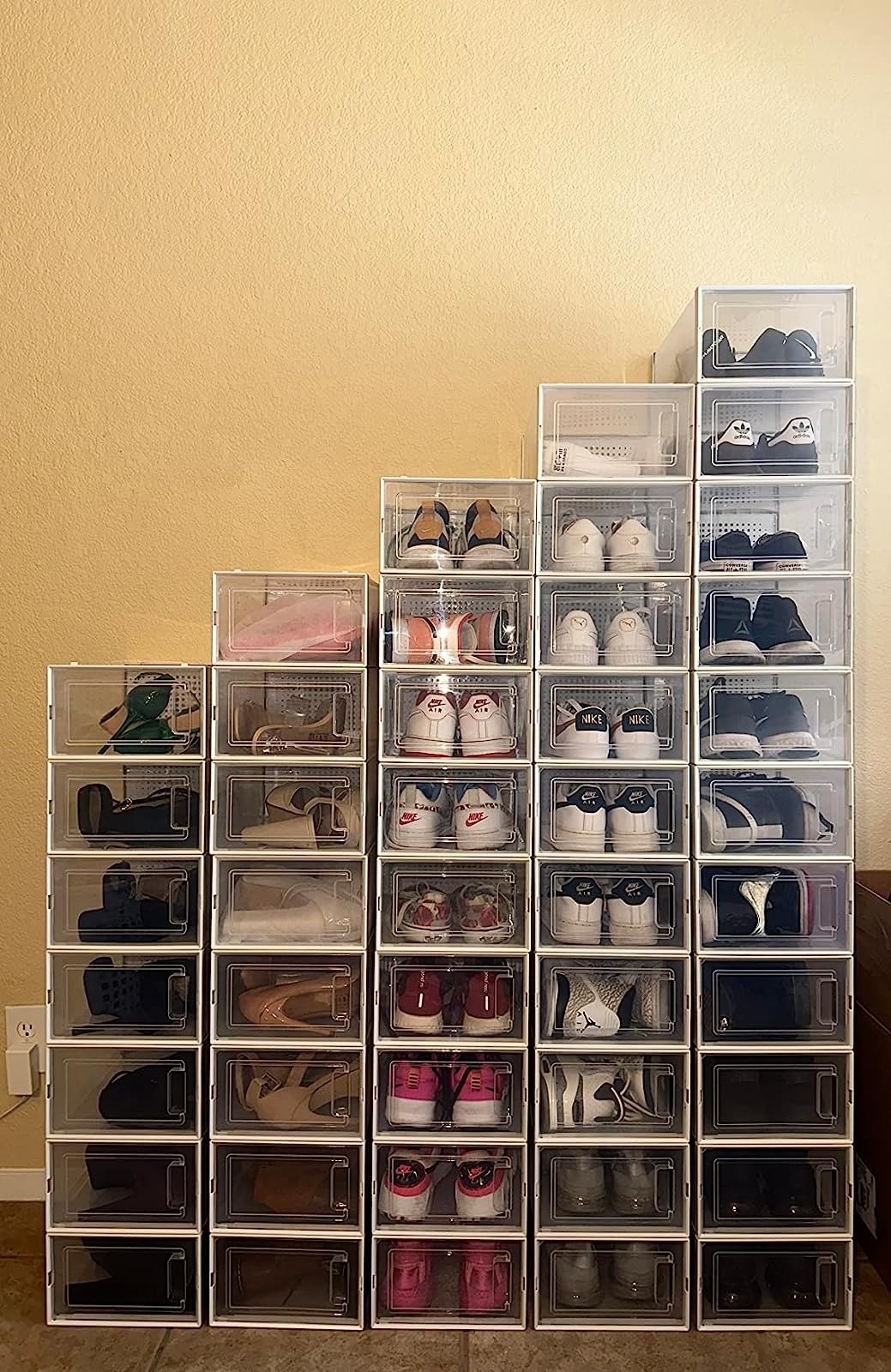 Reviewers&#x27;s photo of storage boxes with shoes stacked against a wall.