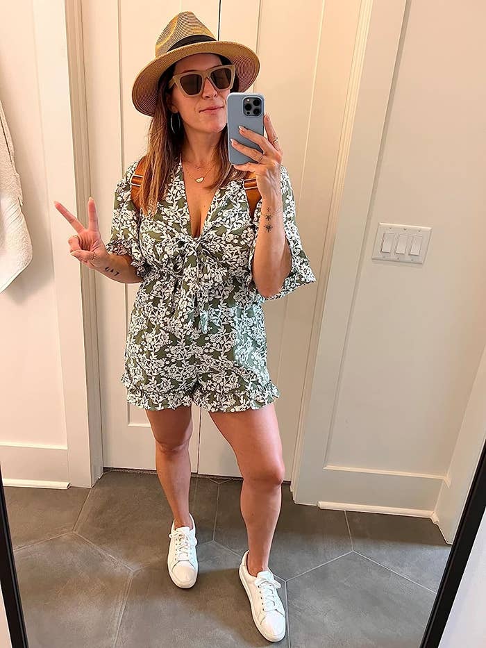 Reviewer wearing the printed romper and sneakers