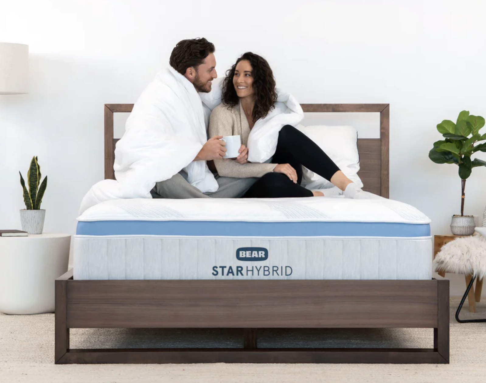 Two people snuggle on a mattress