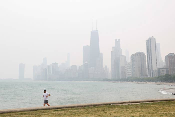 A man running along the Chicago riverfront with a hazy skyline in the background