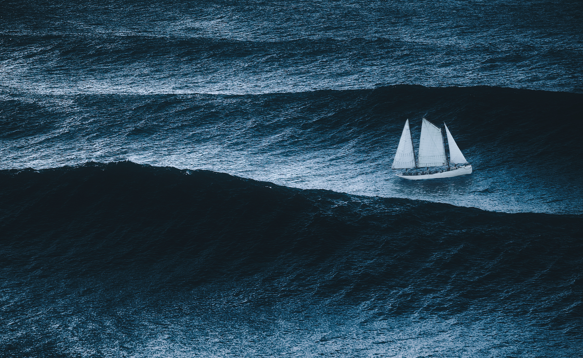 sail boat getting caught between waves