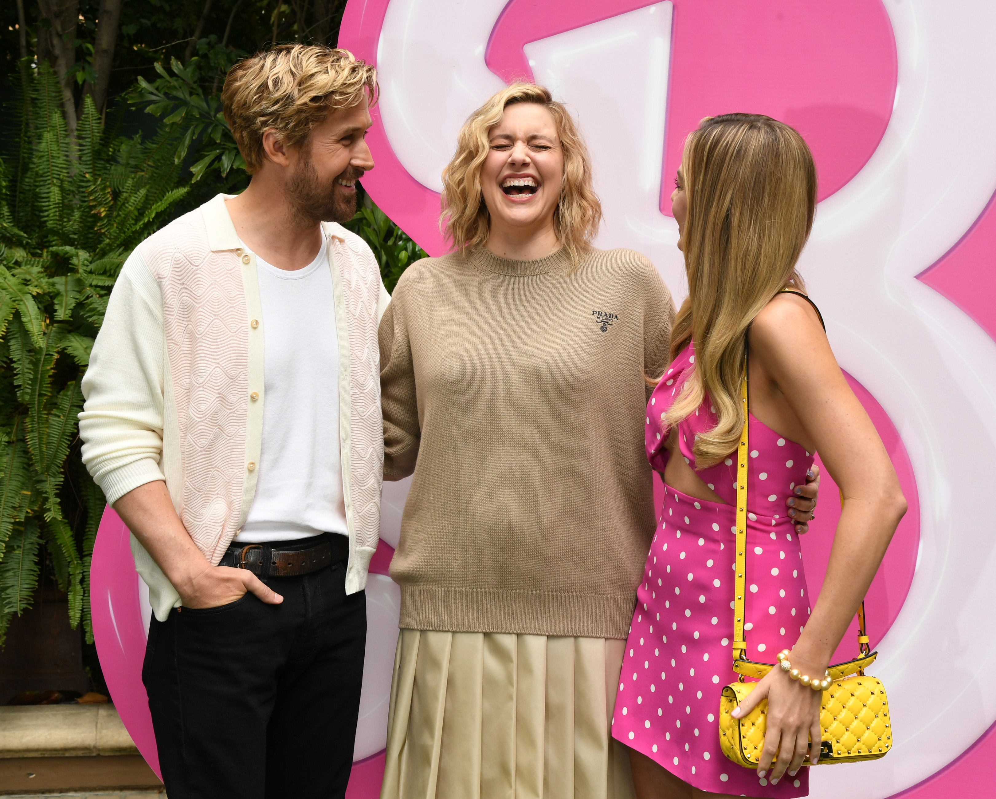 Greta laughing as she talks with Ryan Gosling and Margot Robbie